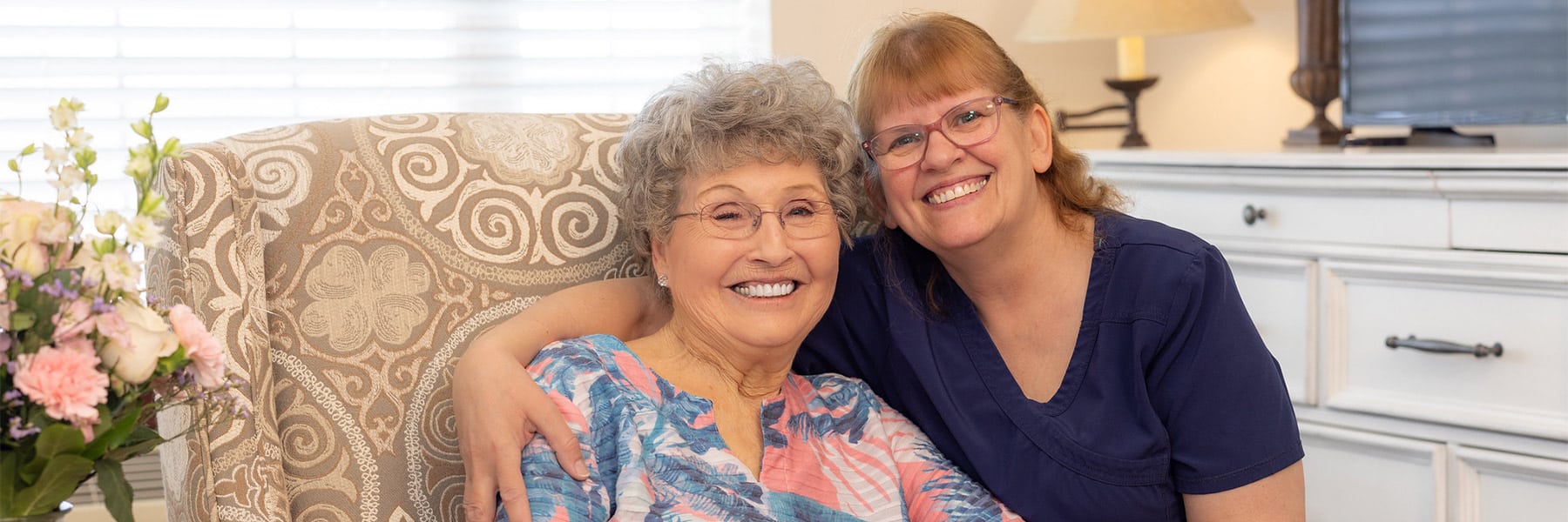 nurse posing with resident smiling at the Villages of Jackson Creek