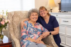Nurse posing with resident smiling at the Villages of Jackson Creek